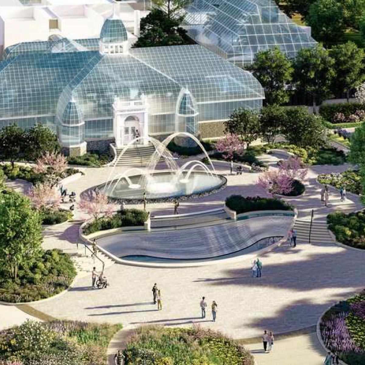 A glass conservatory building with curved roofs stands behind a large, modern fountain and landscaped gardens. People walk along paved paths surrounded by greenery, flowers, and trees.